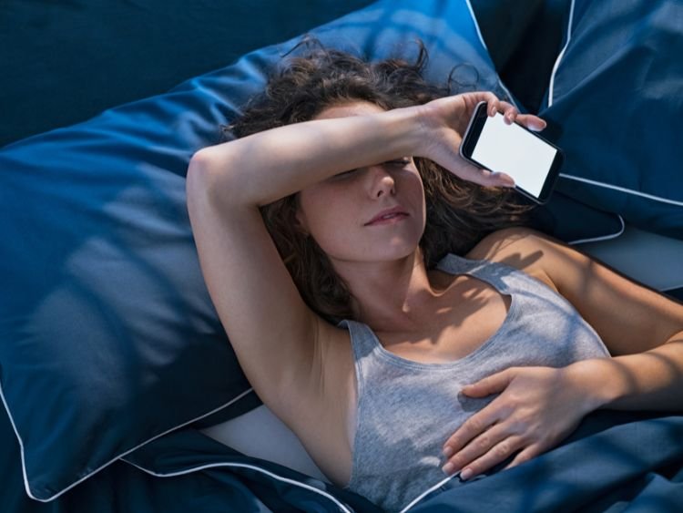 Mulher com insônia, ficou a noite toda mexendo no celular e acabou tendo dificuldades para dormir. Ela ainda não descobriu o Segredo da Qualidade de Vida