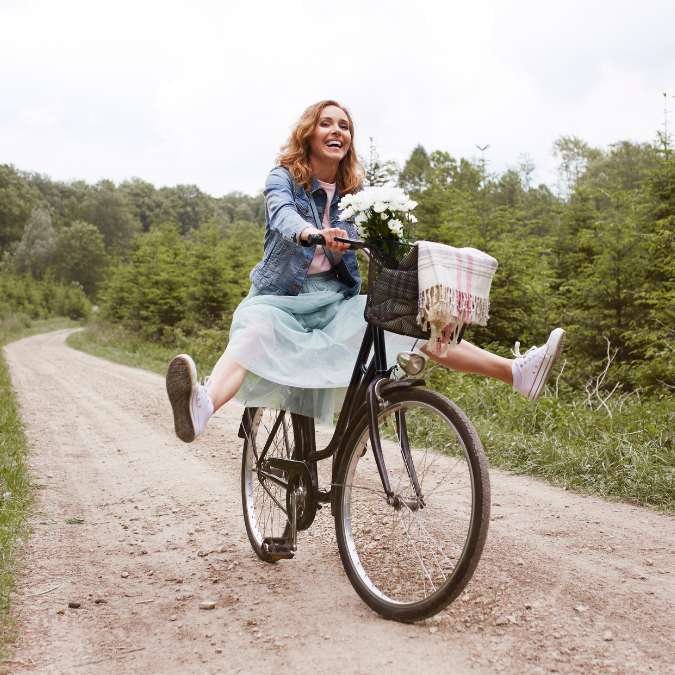 Mulher andando de bicicleta feliz.