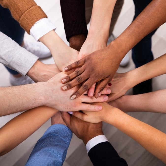 Diversas pessoas reunidas em um círculo, simbolizando o apoio mútuo e o crescimento conjunto.