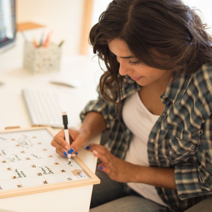 Mulher escrevendo indicando planejamento e organização na construção de hábitos.