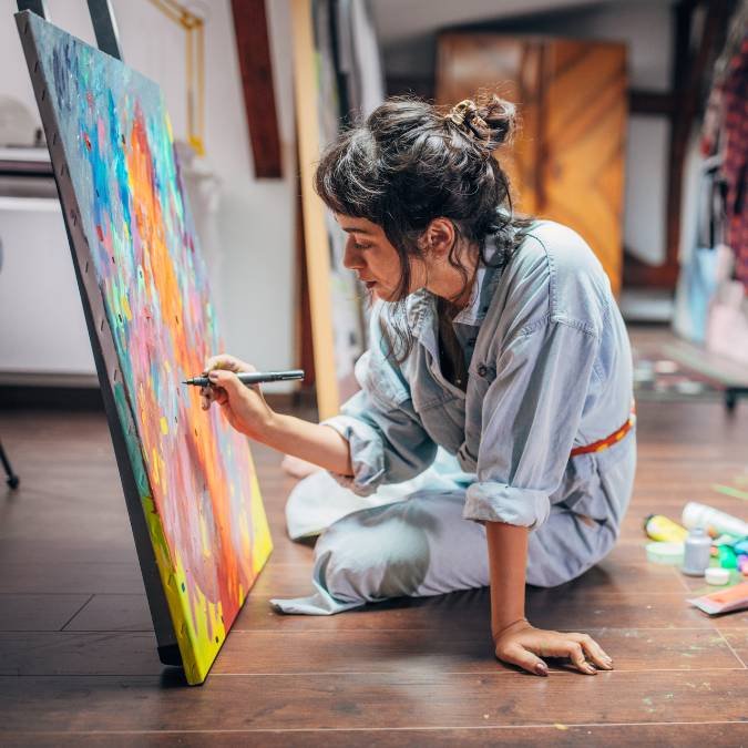 Mulher pintando um quadro para refletir o prazer das atividades realizadas longe das telas.