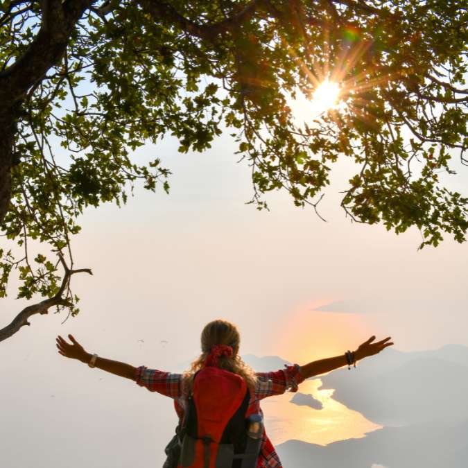 Uma mulher desfrutando de uma paisagem representando a essência de uma vida desconectada e plenamente vivida.