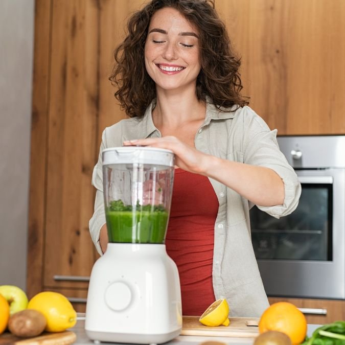Mulher preparando um suco verde.