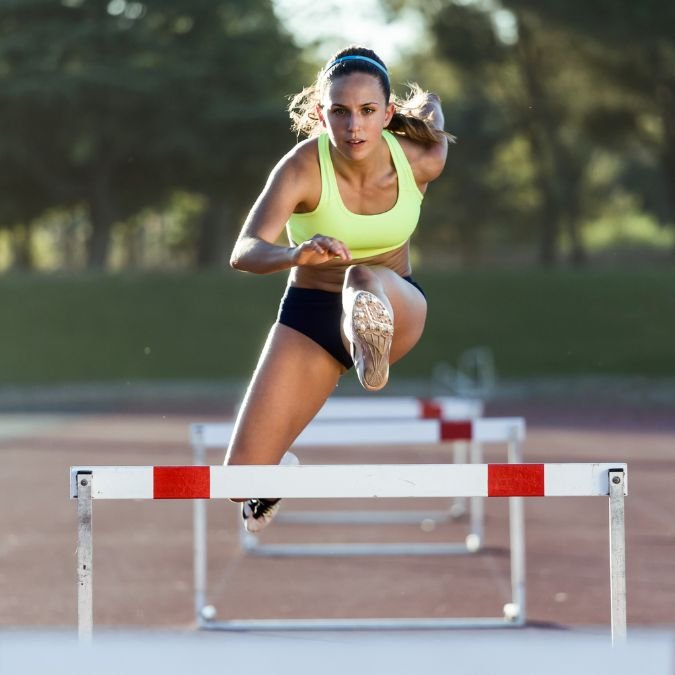 Atleta em um momento desafiador do salto sobre obstáculo.