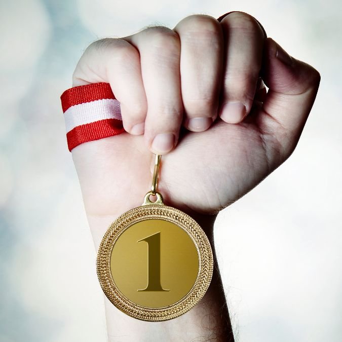Mão segurando uma medalha.