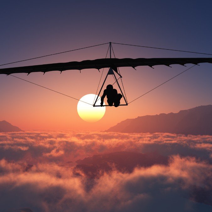 Mulher voando de asa delta.