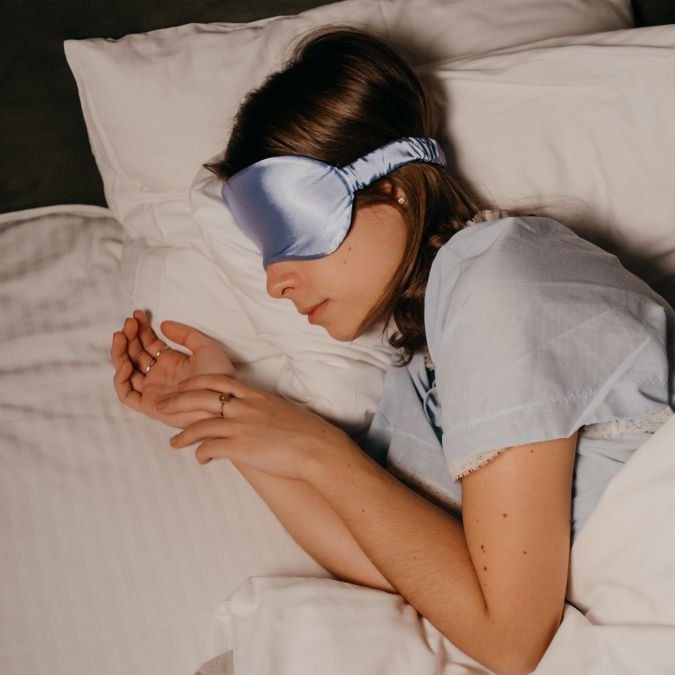Mulher dormindo profundamente após fazer uma excelente higiene do sono à noite.