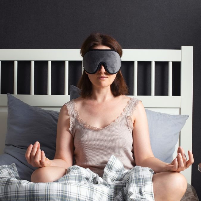 Mulher meditando na cama.