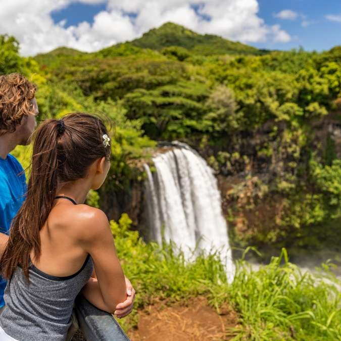 Turistas contemplando uma paisagem natural preservada.