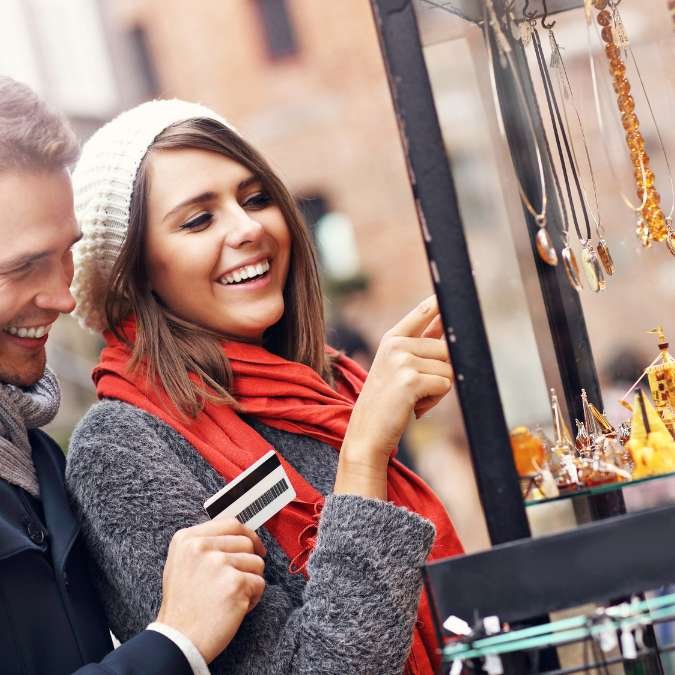 Casal comprando lembranças localmente em viagem.
